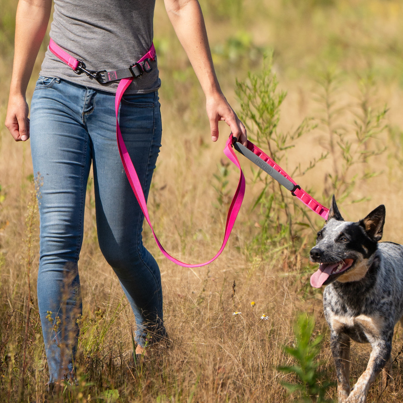 Woman and her dog wearing a multifunctional pink Nuvuq waist leash
